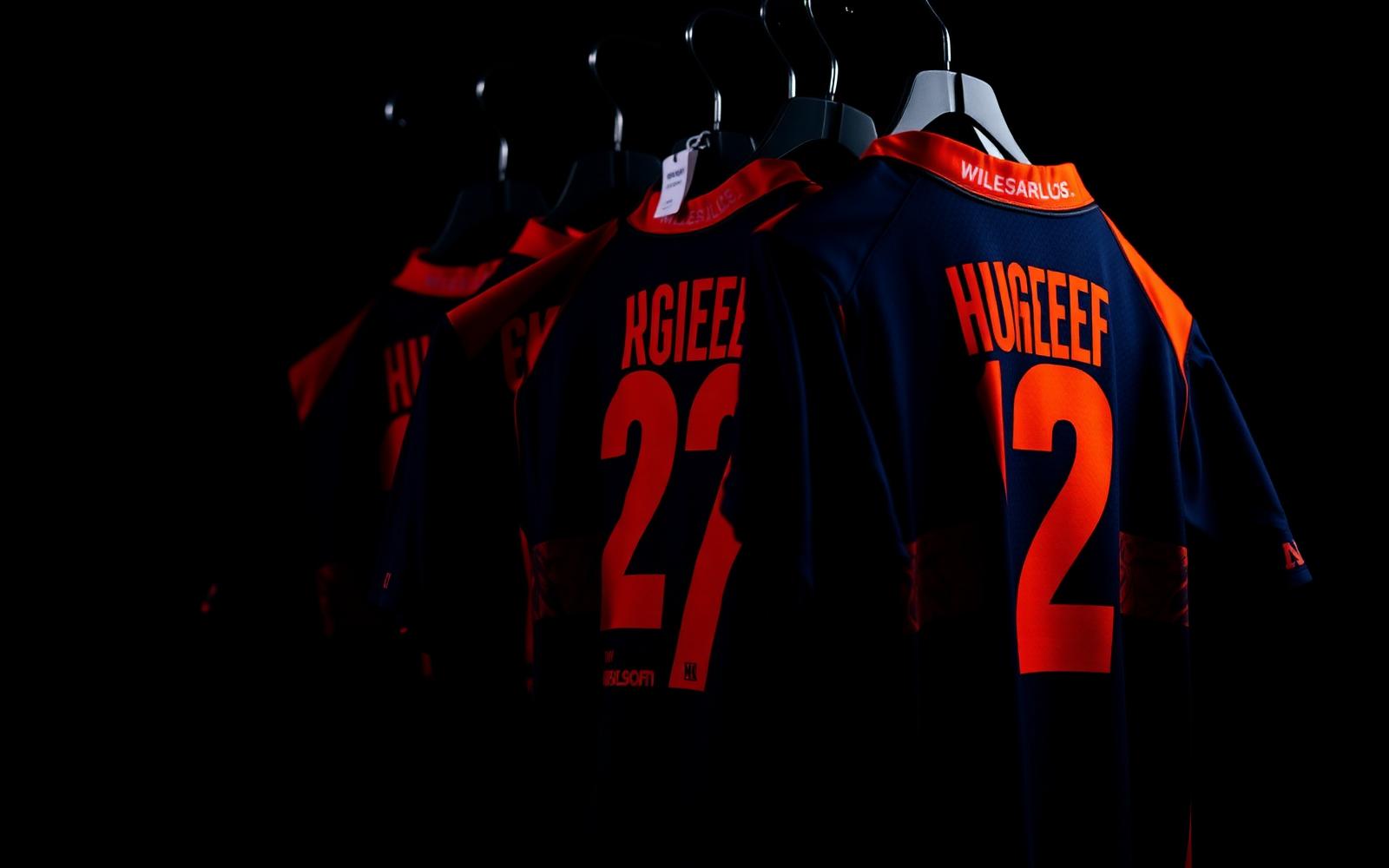 Custom AFL jumpers on hangers in navy and orange club colours